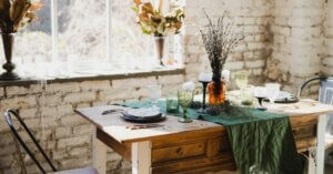 Tavolo in stile rustico apparecchiato con piatti e bicchieri e un vaso