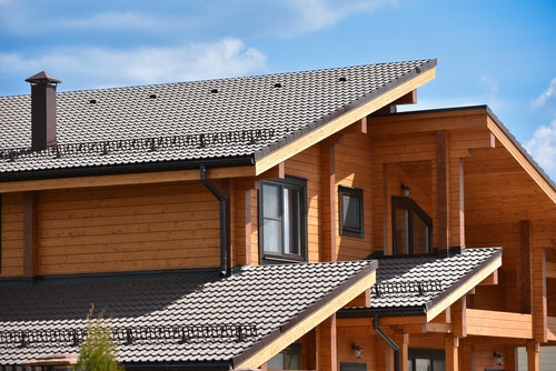 Casa di legno con camino e tetto di tegole.