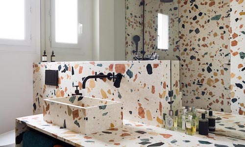 Lavabo del bagno e pareti con texture graniglia.