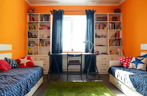 Camera da letto dei ragazzi con pareti arancioni.