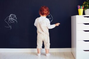 Bambino che disegna su una parete.