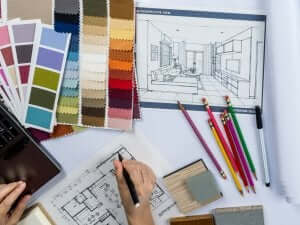 Un designer d'interni lavora a un progetto con delle palette di colori.