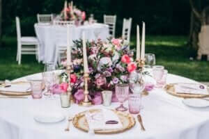 Una tavola romantica con fiori e bicchieri rosa.