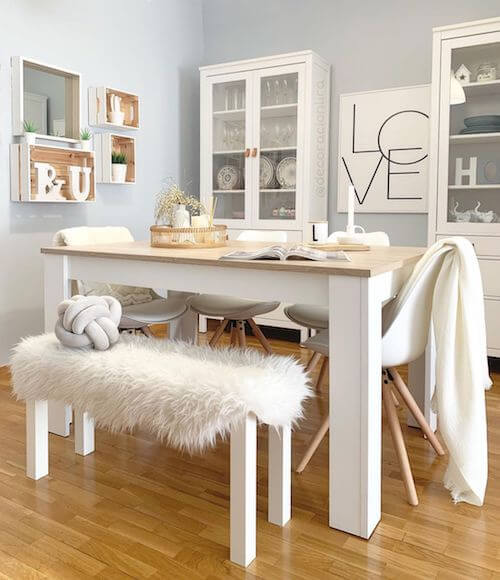Sala da pranzo con tavolo e sedie in legno bianco.