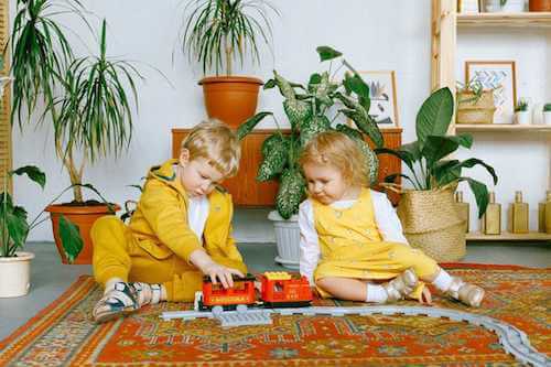 Bambini che giocano in una stanza decorata con le piante.
