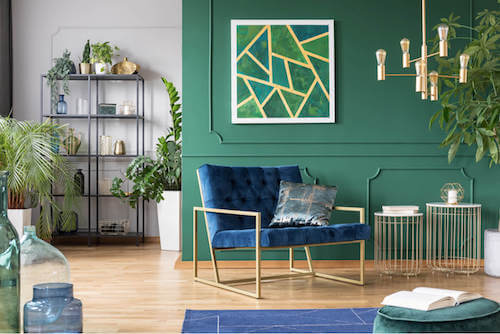 Soggiorno con parete verde e quadro con motivi geometrici.