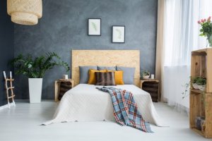 Een slaapkamer met witte wanden en grijstinten