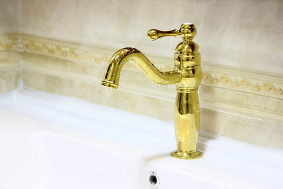 Gouden kraan voor een rustieke badkamer