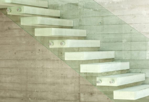 Witte betonnen trap met zijwand van glas