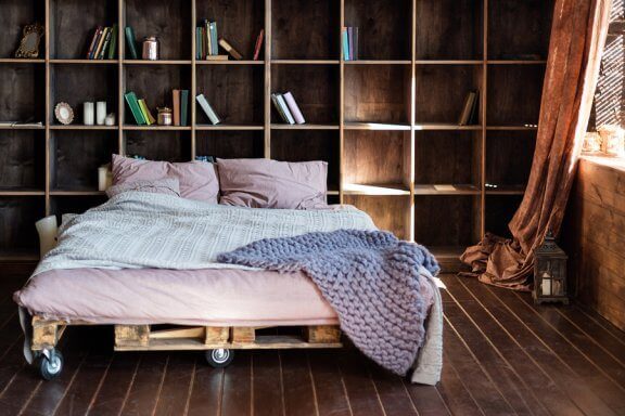 Slaapkamer met een bed van pallets