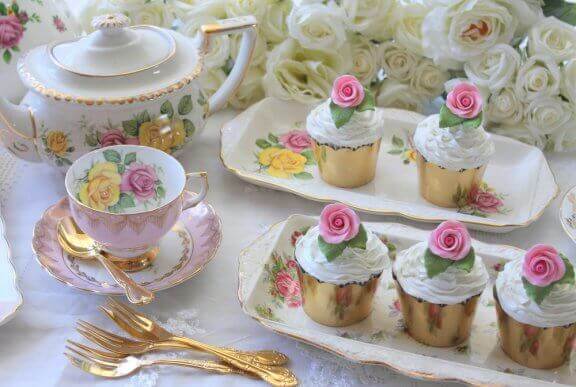 Porselen çay takımı, altın rengi servis ve kap kekler. 