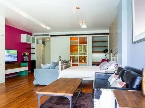 Bir duvarı farklı renk olan iki koltuklu yatak odası