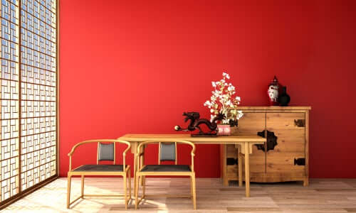 Sade kırmızı bir duvarın önünde açık renk ahşap mobilyalar