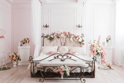 A wrought iron bed with pink flower decor