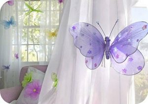 You can decorate white children's curtains with butterfly pins to add some color.