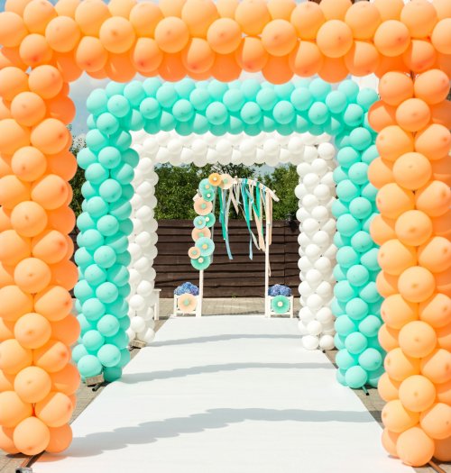 Balloon arch in orange, white and turquoise.