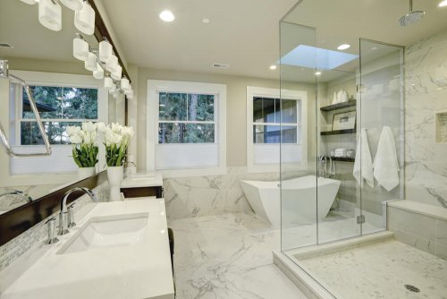 Large bright bathroom decorated in white marble.