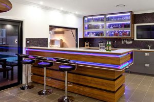 Add a shelf or cupboard where you can keep drinks for your home bar.