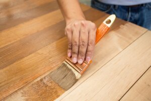 A person staining wood.