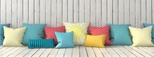 By lots of different sizes of cushions to create a more dynamic look.