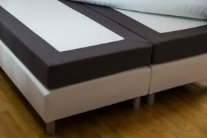A picture shows a pair of twin bed frames connected to make a larger bed with mattresses on top.
