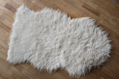 A white sheepskin rug on a timber floor