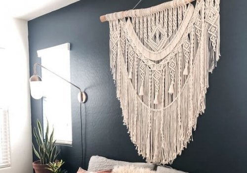 A macrame wall hanging is used instead of a bed headboard as a bedroom feature
