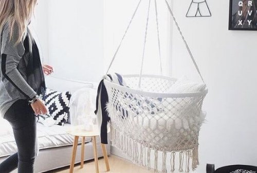 A white baby cot hanging from the ceiling