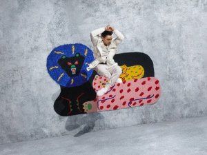 A person jumping in the air to pose with Misaki Kawai's rug.