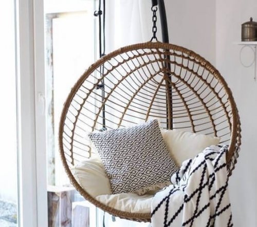 A round free standing swing with cushions and blankets