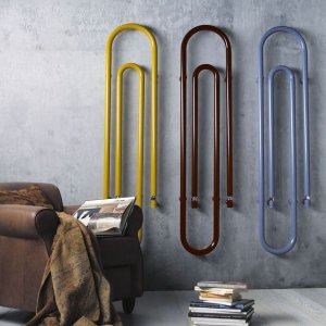 A picture showing vintage radiators snaking up a wall, painted in three different colors.