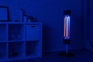 A space heater is on in a room bathed in blue light.