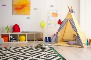 A picture showing how to decorate a toy library: with a tent, a rug, and some fun wall decorations.