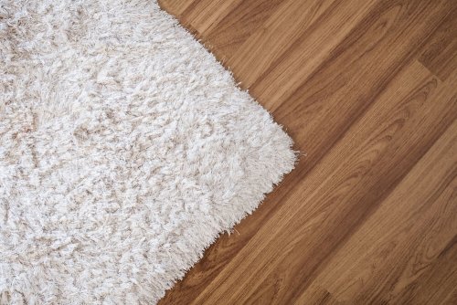 A white long pile woolen rug on a timber floor