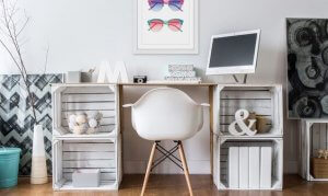 A chic desk with a lot of small decorations sitting in and on top of it.