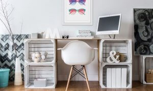 A chic desk with a lot of small decorations sitting in and on top of it.
