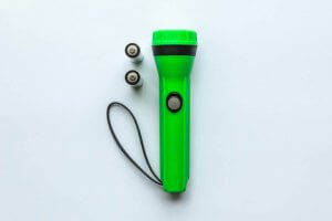 A green flashlight with batteries. 