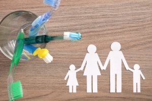Paper figurines next to a toothbrush holder.