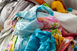 A huge pile of clothes in the middle of a room.
