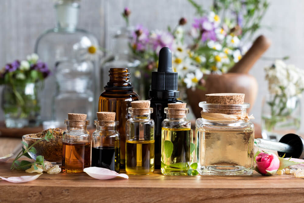 An assortment of essential oils on a wooden slab.