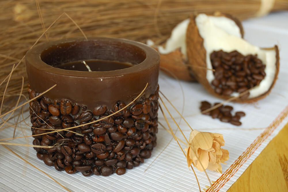 A scented candle with coffee beans on it.