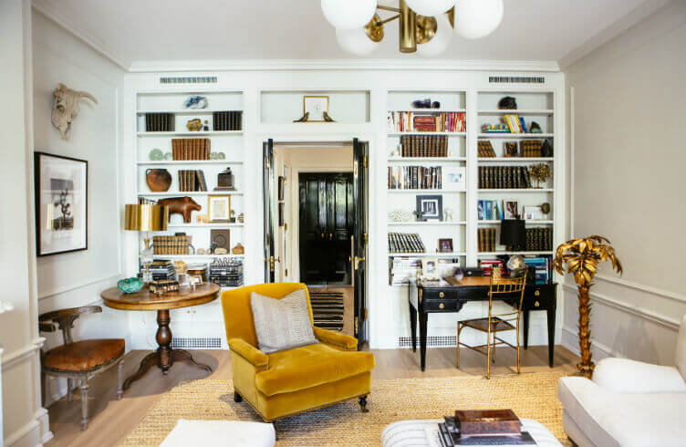 A home study with an armchair, desk, and bookshelves.