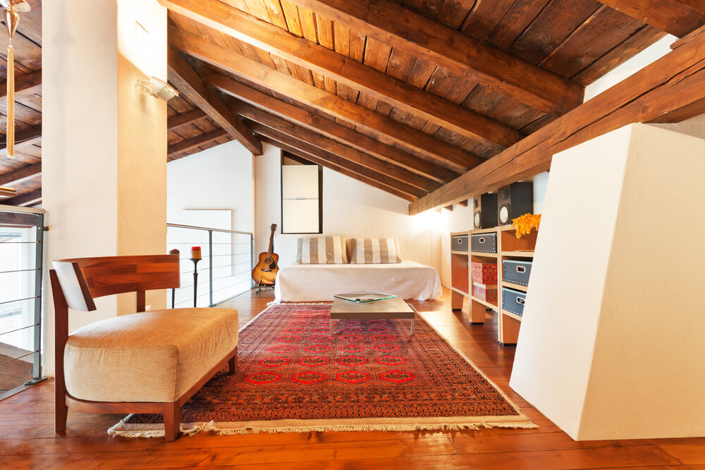 A loft with a slanting wood ceiling.