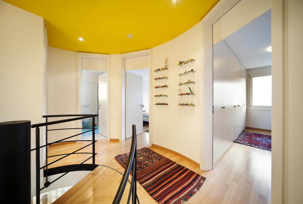 A simple ceiling design with yellow paint and lights installed within.