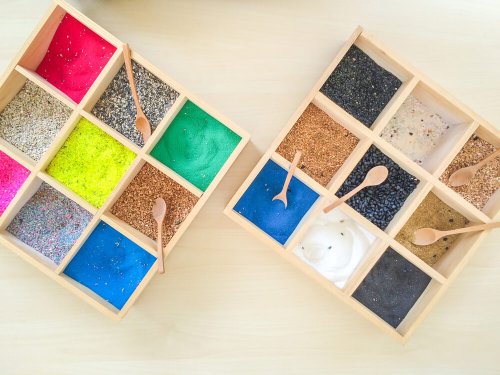 A couple boxes with colored sand.