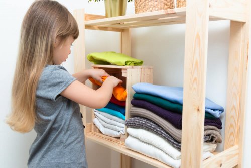 A girl looking through a pile of t-shirts.