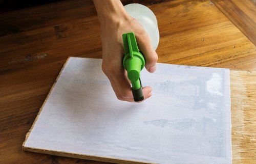 A person spraying a print.