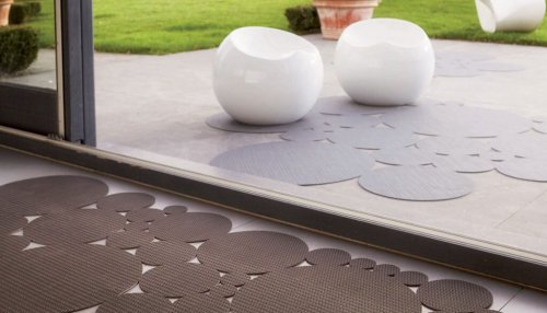 A room and patio with die cut rugs.