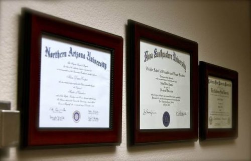 Three academic diplomas on the wall.