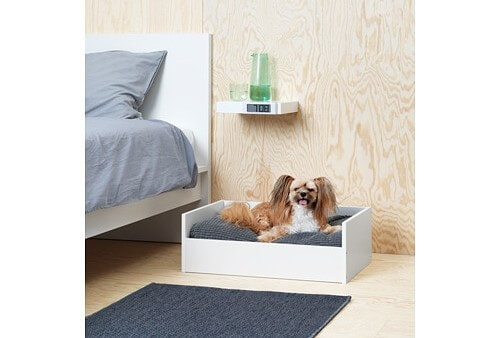 A dog on their bed, part of IKEA's pet collection.